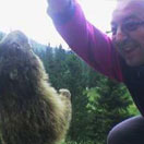 In montagna, mentre giocherella faccia a faccia con una marmotta